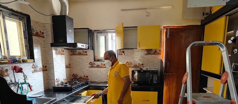 Cockroach spray treatment in progress in a residential kitchen by Satish Pest Control technician